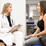 Female doctor explaining diagnosis to her young woman patient.